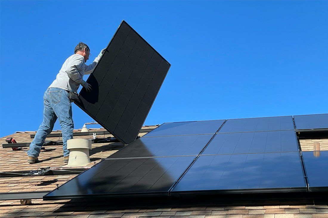 Man is Installing Solar Panels on the Roof of a House — MoneySmith Group In Kingscliff, NSW