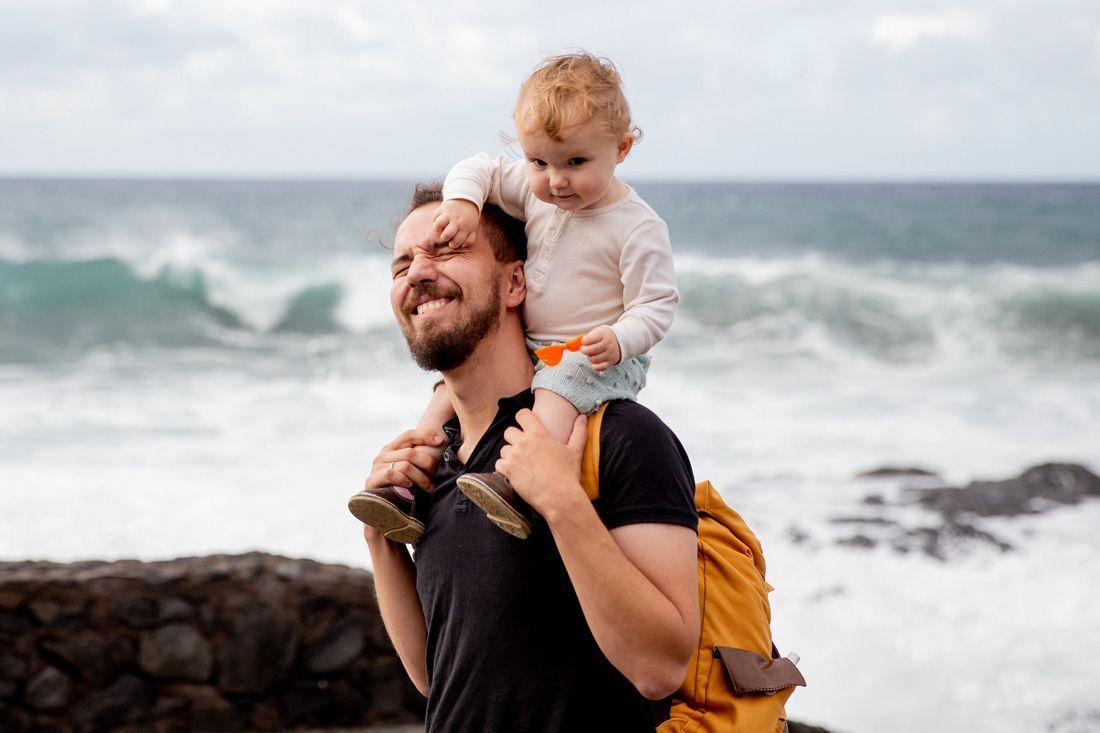 A Man is Carrying a Baby on His Shoulders — MoneySmith Group In Kingscliff, NSW