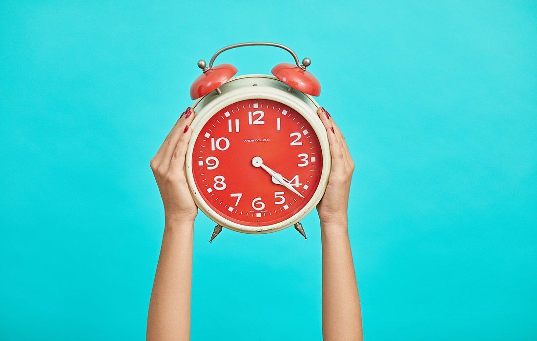 A Woman is Holding an Alarm Clock — MoneySmith Group In Kingscliff, NSW