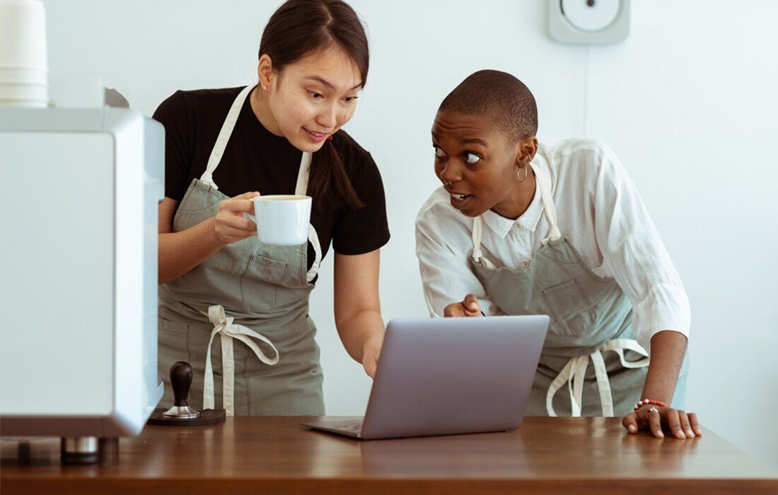 Two Woman Are Looking At A Laptop Computer — MoneySmith Group In Kingscliff, NSW