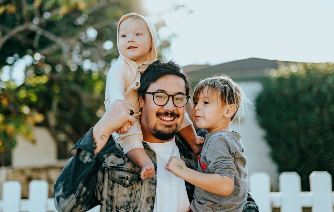 Man is Carrying His Two Children — MoneySmith Group In Kingscliff, NSW
