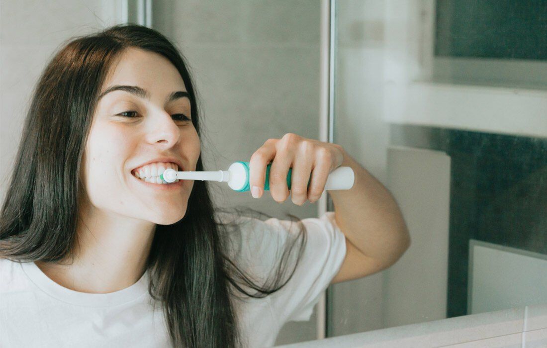 A Woman is Brushing Her Teeth — MoneySmith Group In Kingscliff, NSW