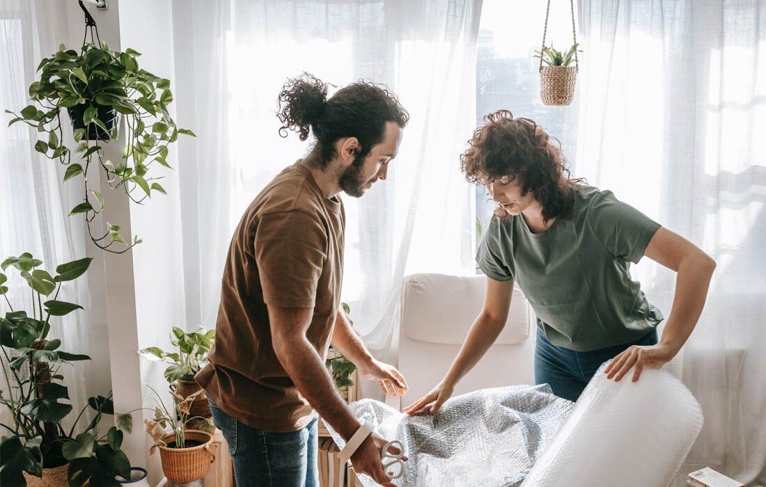 Man and a Woman Are Packing a Mattress in a Living Room — MoneySmith Group In Kingscliff, NSW