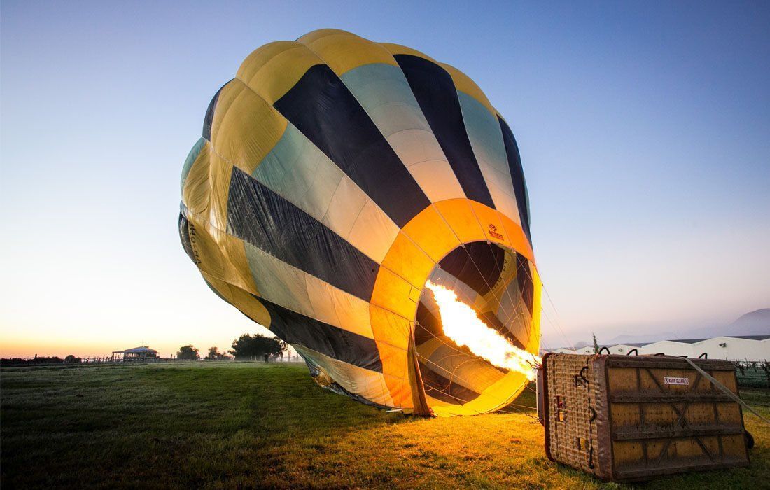 Hot Air Balloon is Being Inflated in a Field — MoneySmith Group In Kingscliff, NSW