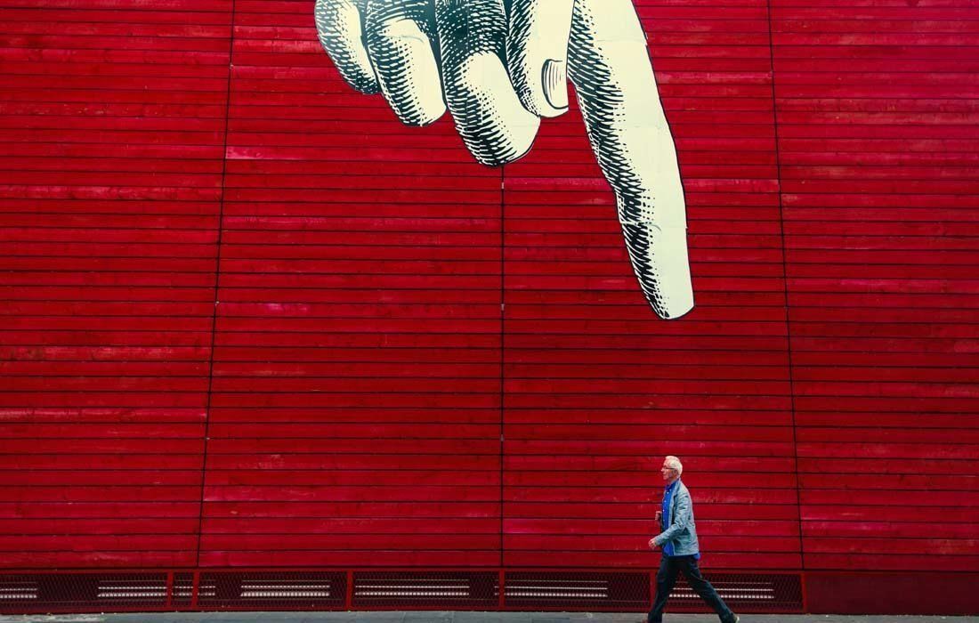 A Man is Walking in Front of a Red Wall — MoneySmith Group In Kingscliff, NSW