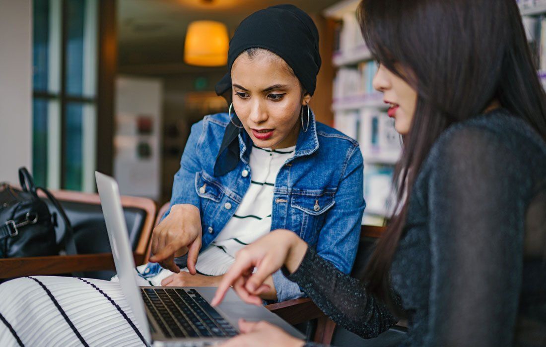 Two Women Are Sitting at a Table — MoneySmith Group In Kingscliff, NSW
