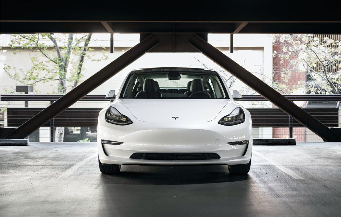 White Tesla Model 3 is Parked in a Parking Garage — MoneySmith Group In Kingscliff, NSW