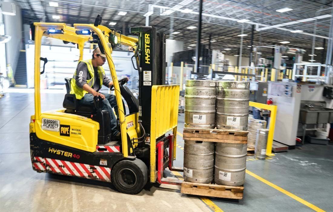 Man is Driving a Yellow Forklift in a Warehouse — MoneySmith Group In Kingscliff, NSW