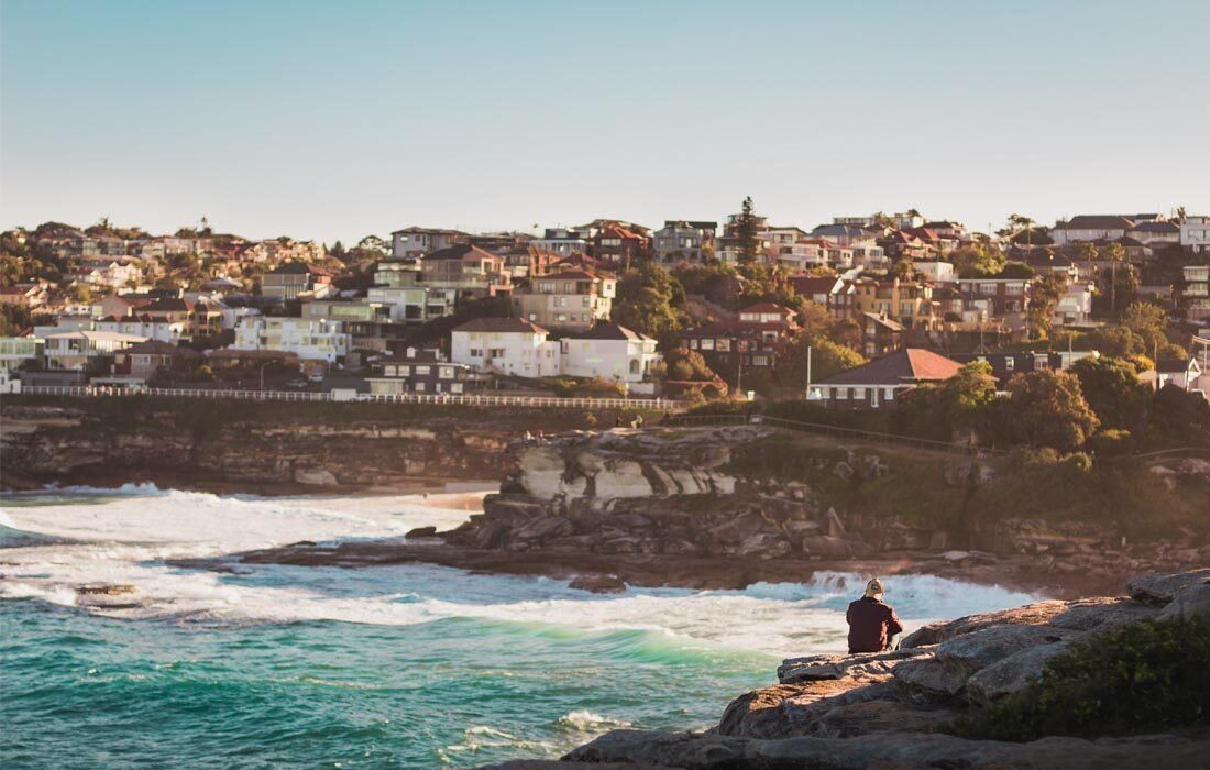 A Man is Sitting on a Rock in the Ocean — MoneySmith Group In Kingscliff, NSW