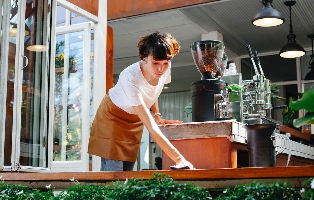 Woman is Cleaning a Table — MoneySmith Group In Kingscliff, NSW
