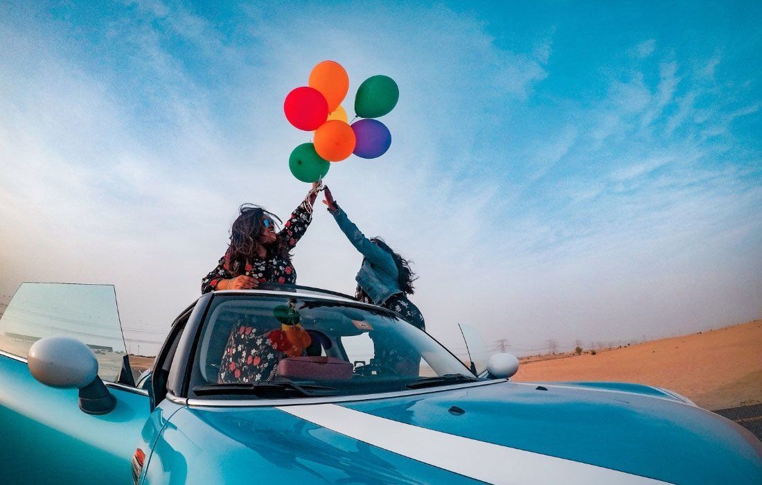 Two Women Are Holding Balloons in a Car — MoneySmith Group In Kingscliff, NSW