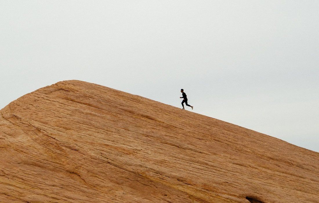 A Man is Standing on Top of a Sandy Hill — MoneySmith Group In Kingscliff, NSW