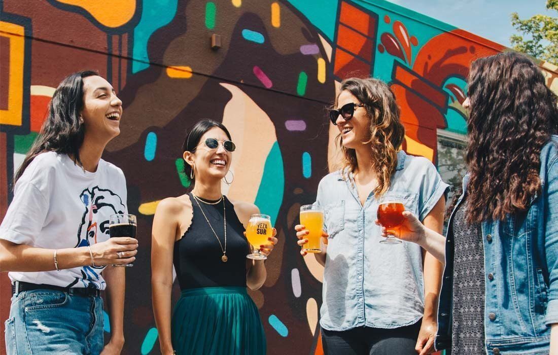 A Group of Women Are Standing in Front of a Mural — MoneySmith Group In Kingscliff, NSW