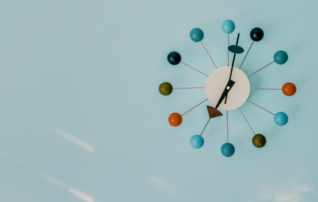 A Colorful Clock is Hanging on a Blue Wall — MoneySmith Group In Kingscliff, NSW
