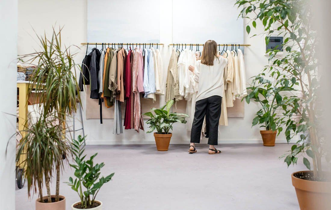 A Woman is Standing in Front of a Clothes Rack — MoneySmith Group In Kingscliff, NSW