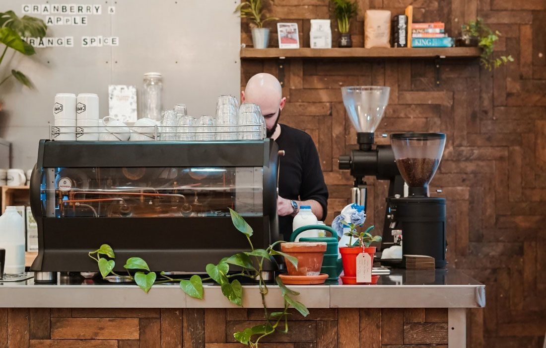 A Man is Standing in a Counter of a Coffee Shop — MoneySmith Group In Kingscliff, NSW