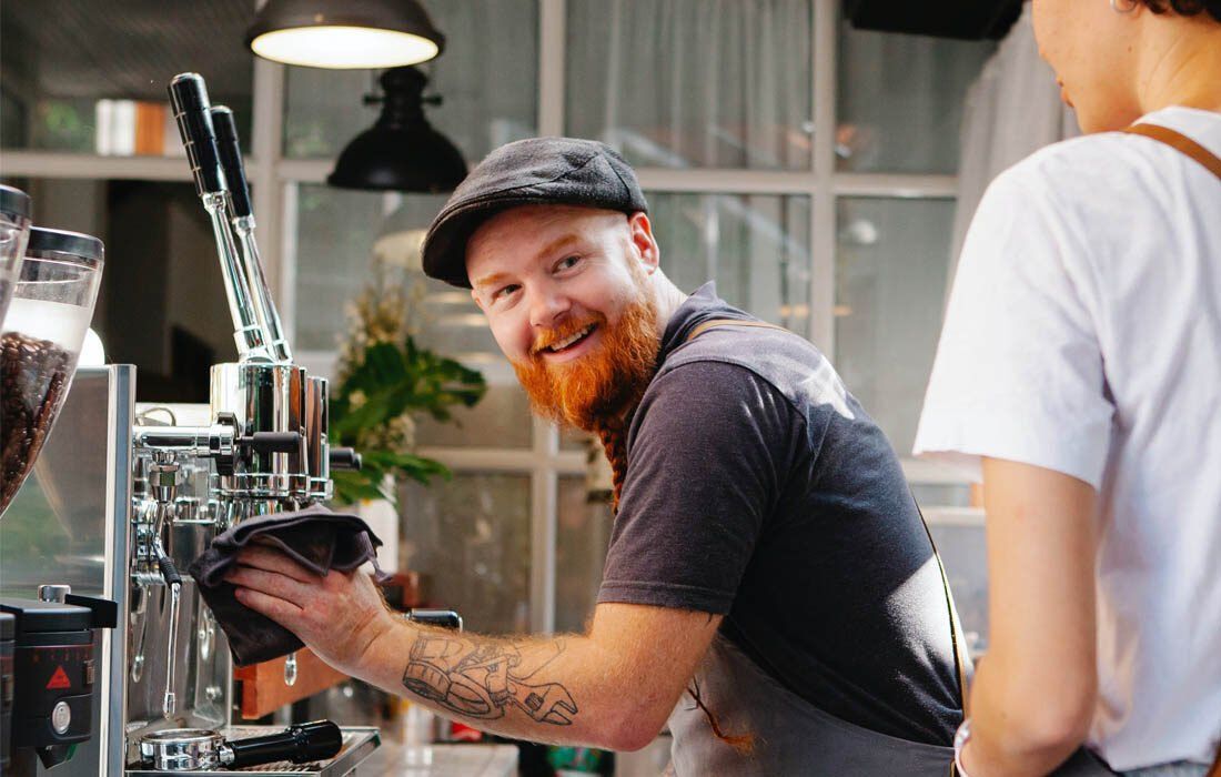 Man is Cleaning a Coffee Machine — MoneySmith Group In Kingscliff, NSW