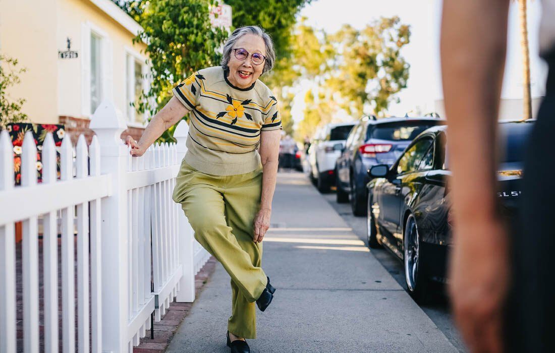 An Elderly Woman is Standing on a Sidewalk — MoneySmith Group In Kingscliff, NSW