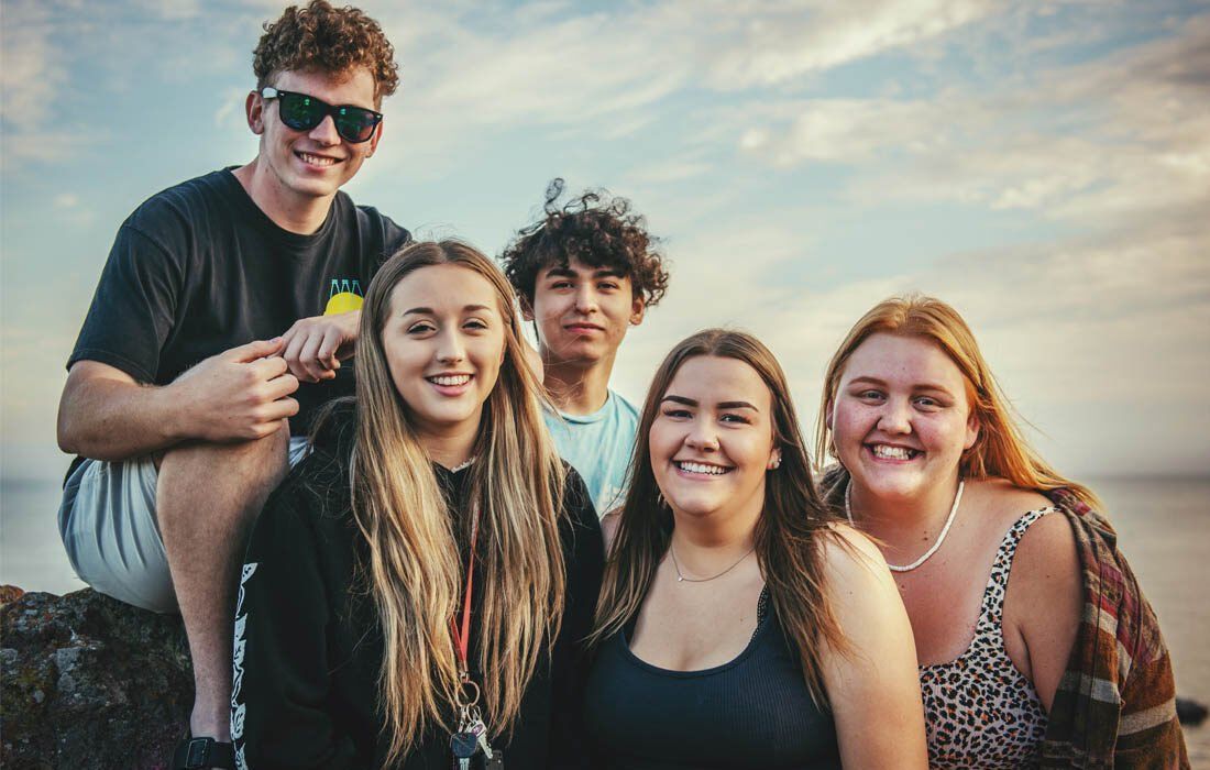 Group of Young People on a Rock Near the Ocean — MoneySmith Group In Kingscliff, NSW