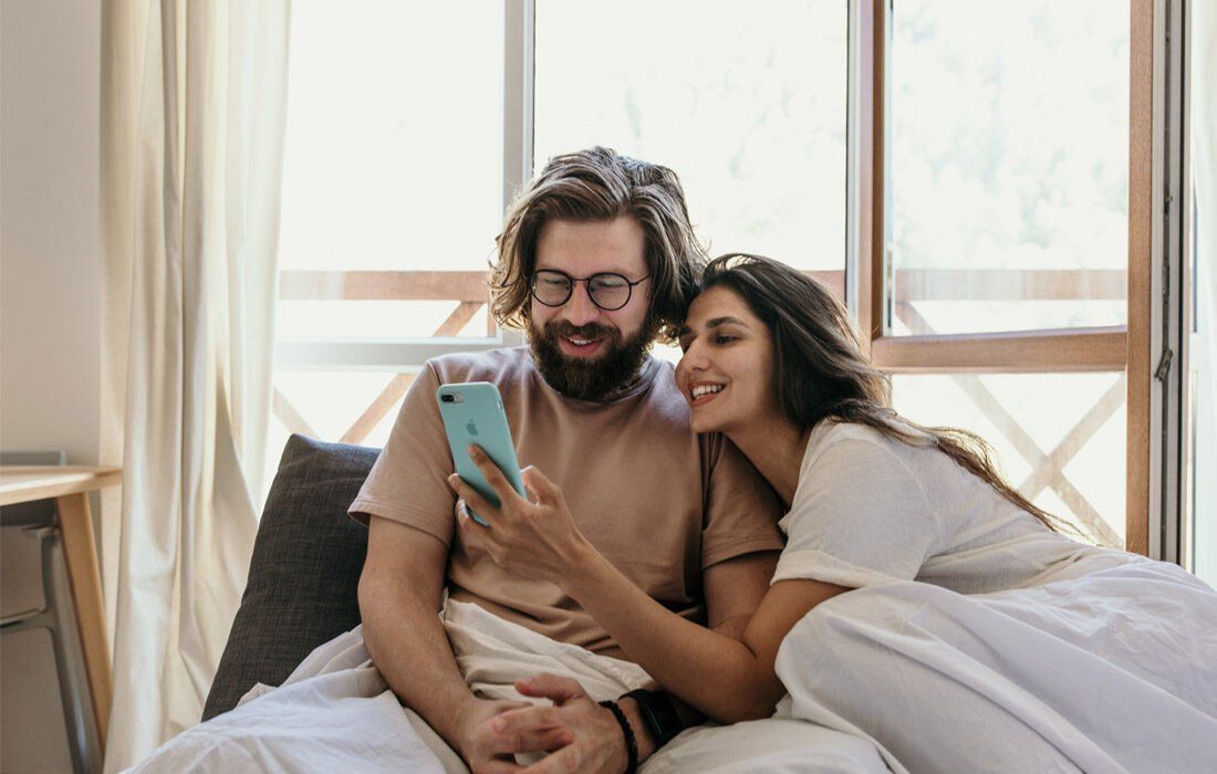A Man and a Woman Are Sitting on a Bed — MoneySmith Group In Kingscliff, NSW