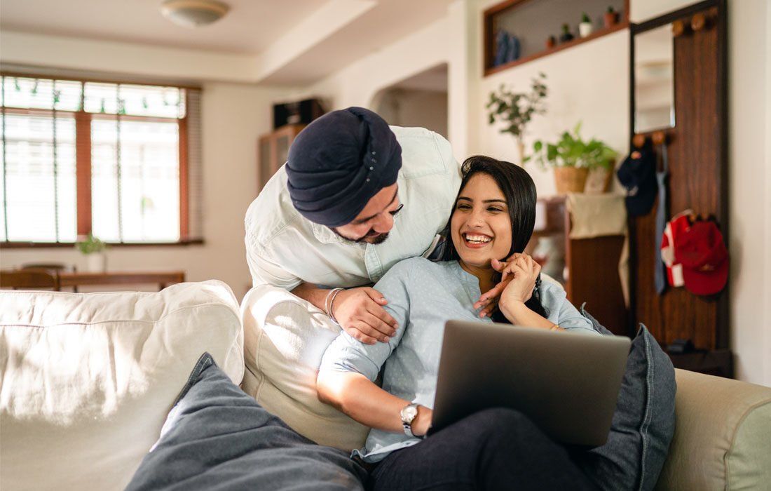 Man is Hugging a Woman While Sitting on a Couch — MoneySmith Group In Kingscliff, NSW