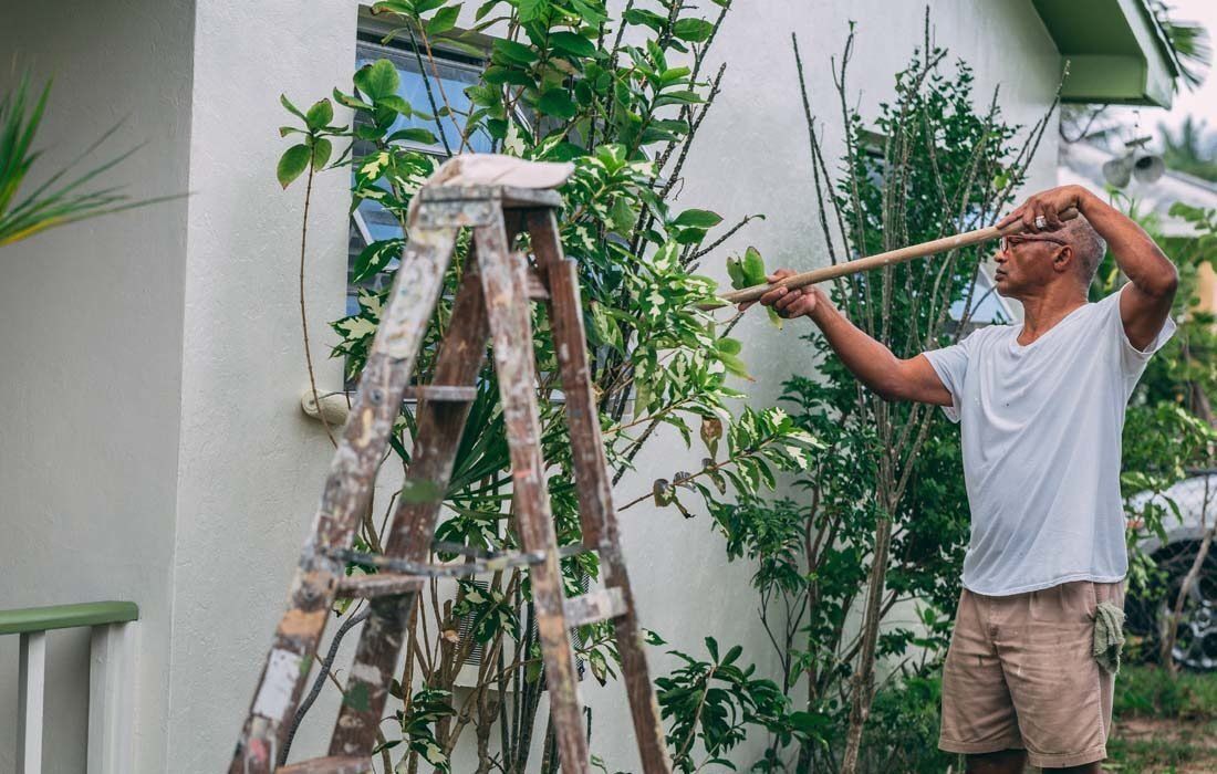 A Man Painting a House — MoneySmith Group In Kingscliff, NSW