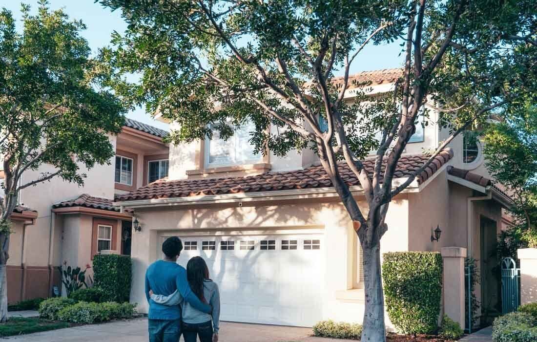 A Couple Standing in Front of a House — MoneySmith Group In Kingscliff, NSW