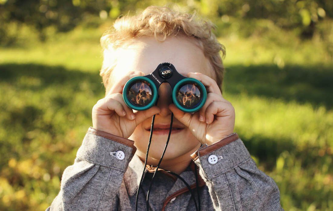 A Young Boy is Looking Through Binoculars — MoneySmith Group In Kingscliff, NSW