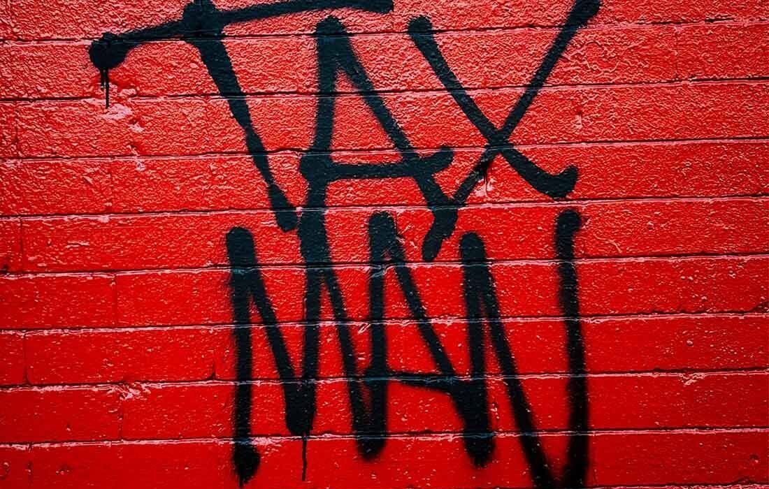Word Tax is Spray Painted on a Red Brick Wall — MoneySmith Group In Kingscliff, NSW