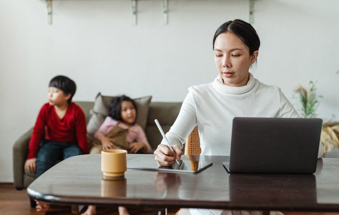 Woman is Sitting at a Table Using a Laptop Computer — MoneySmith Group In Kingscliff, NSW