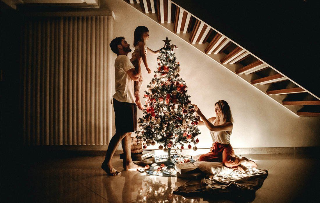 A Family is Decorating a Christmas Tree — MoneySmith Group In Kingscliff, NSW