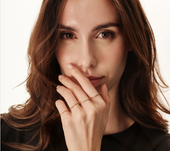 Donna che indossa una collana, orecchini e anello d'argento, tutti con pietre preziose blu, su un abito nero.