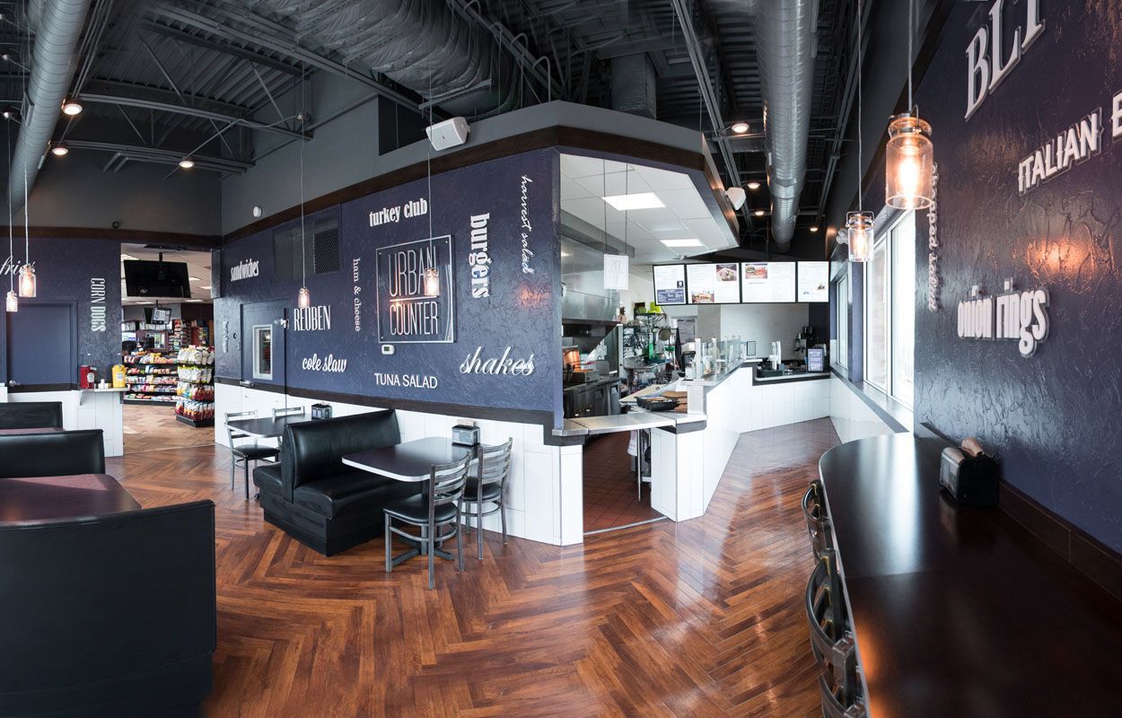 A restaurant with a wooden floor and tables and chairs.