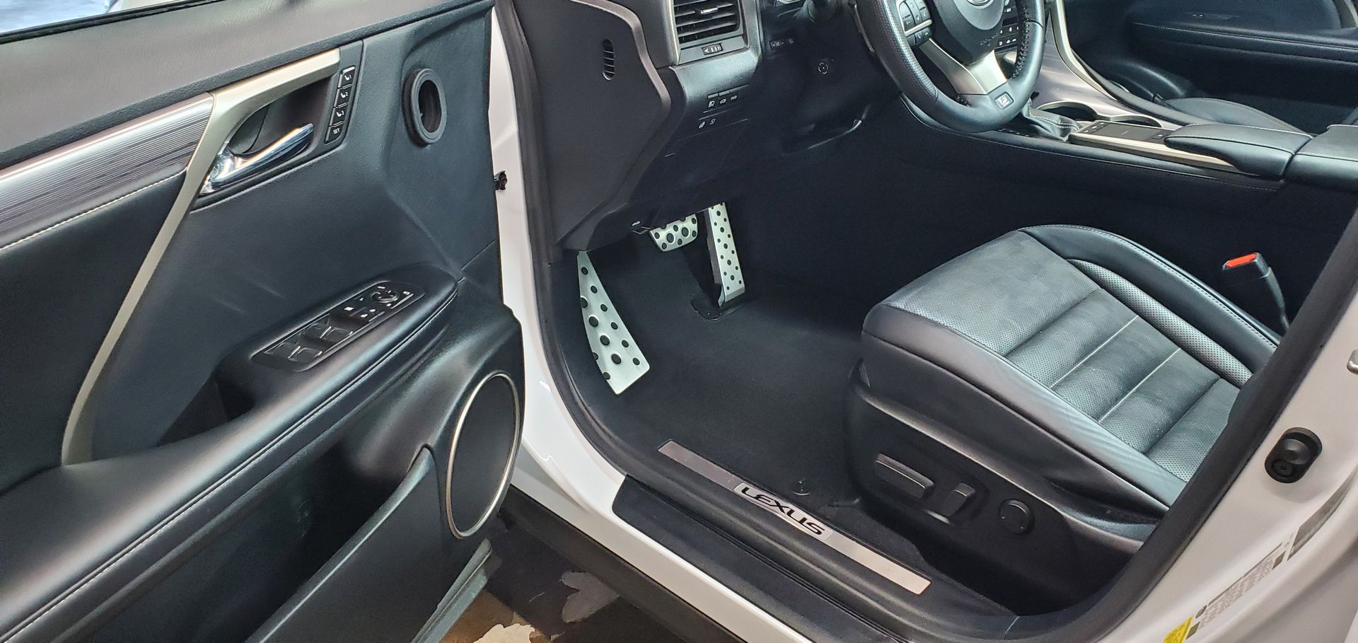 a man is polishing the roof of a car with a machine .
