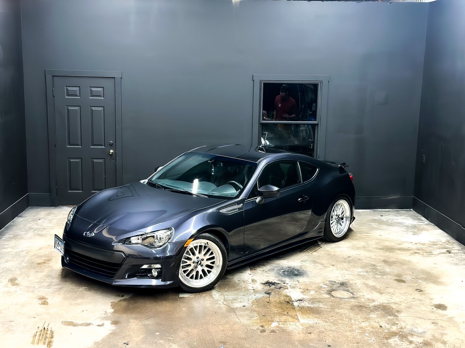 a black sports car is parked in a garage .