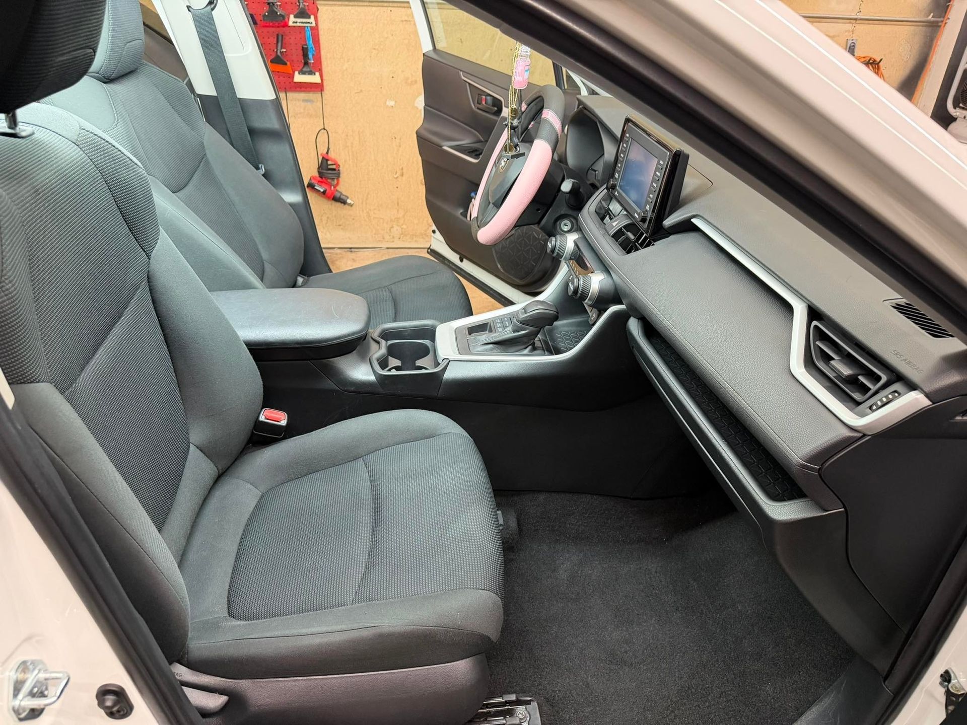 a man is polishing the roof of a car with a machine .