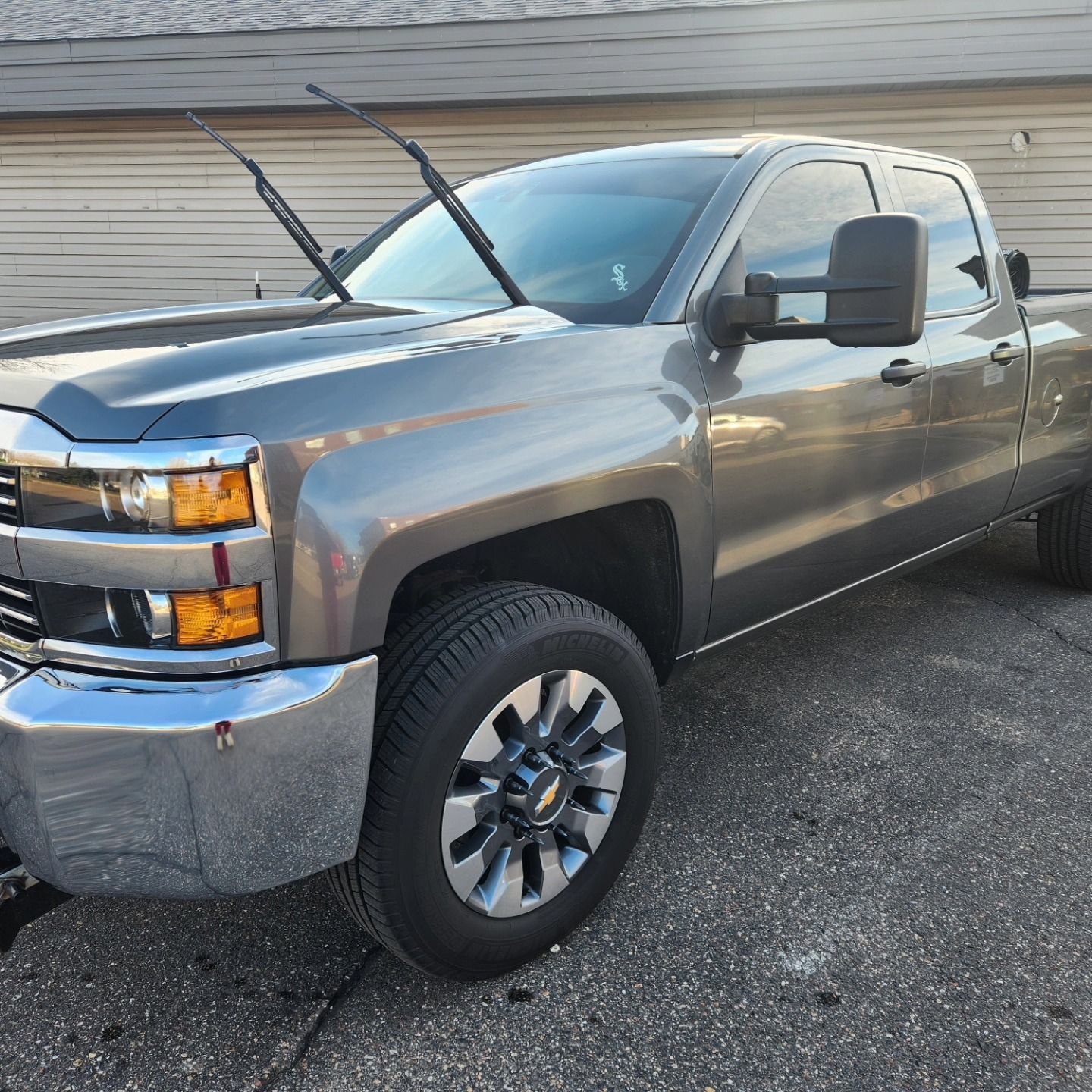 a man is polishing the hood of a car with a polisher .