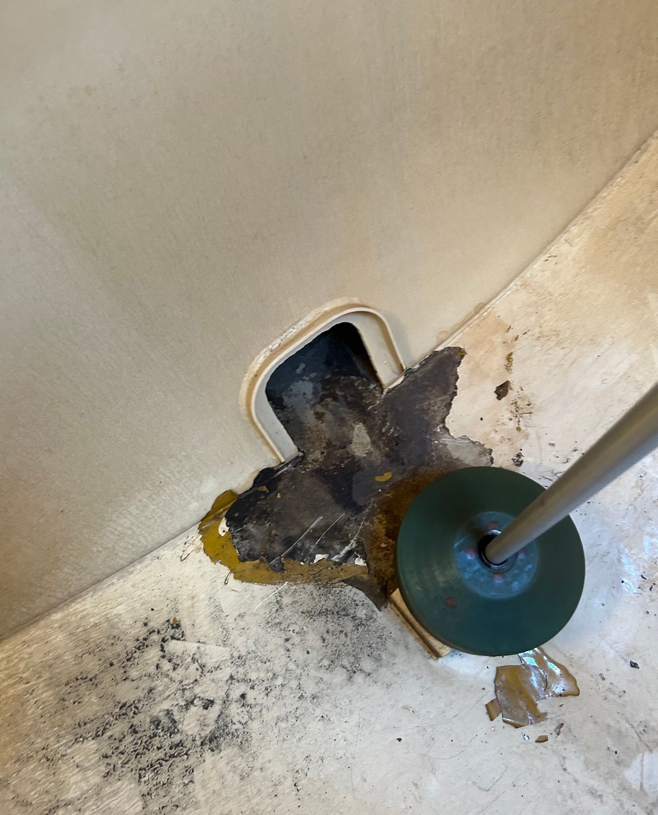 A toilet with a plunger sticking out of it.