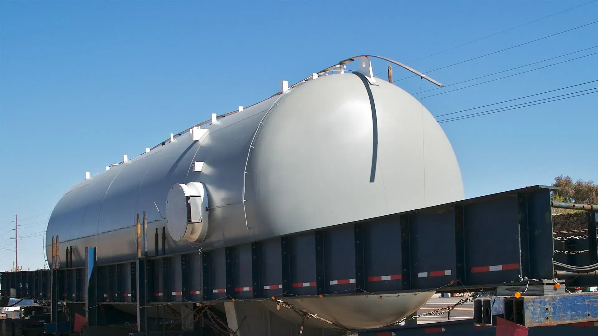 A large white tank is sitting on top of a trailer.