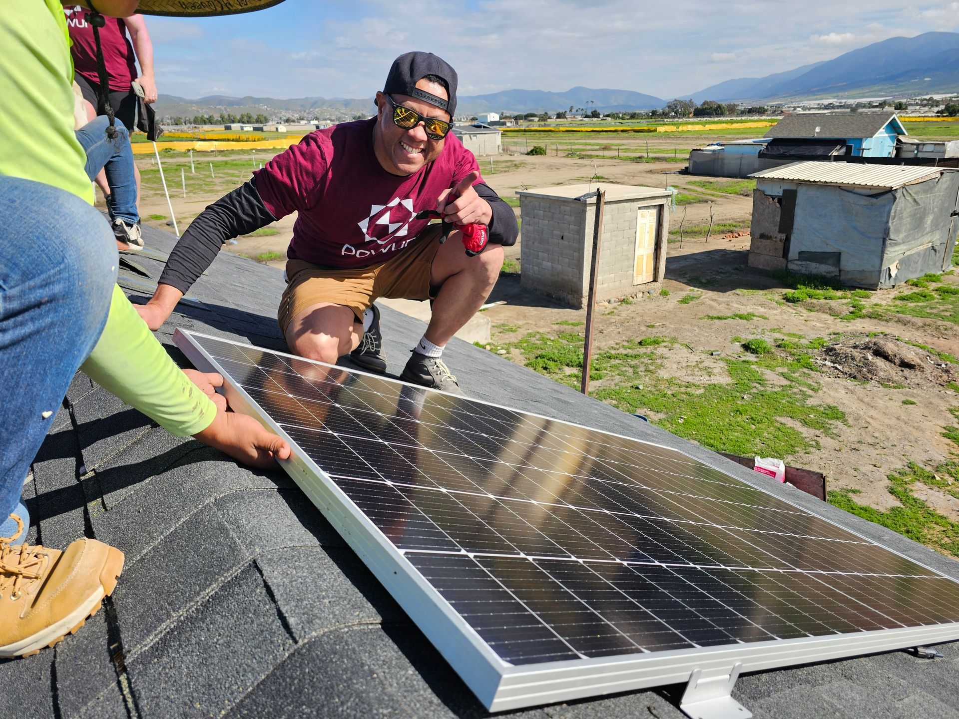 A man is installing a solar panel on a roof.