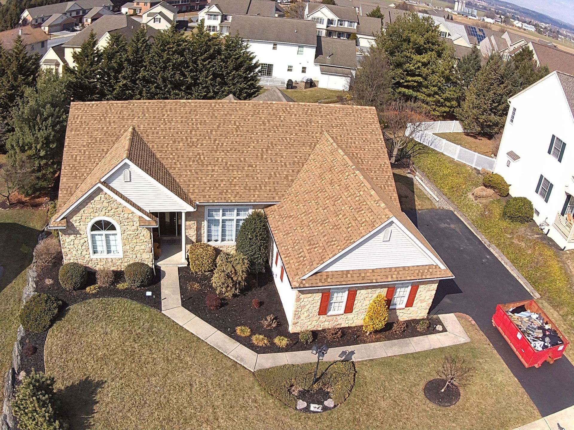 An aerial view of a house with a red car parked in front of it