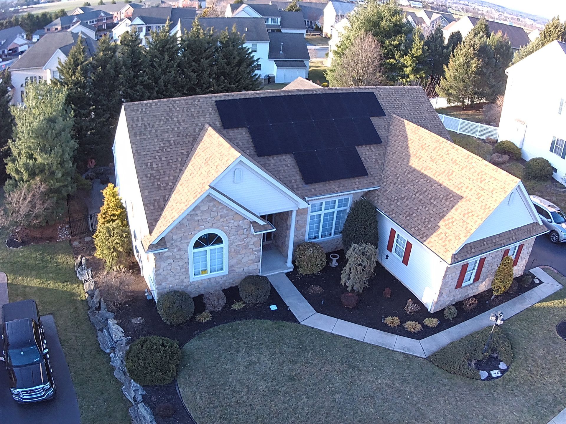 An aerial view of a house with solar panels on the roof.