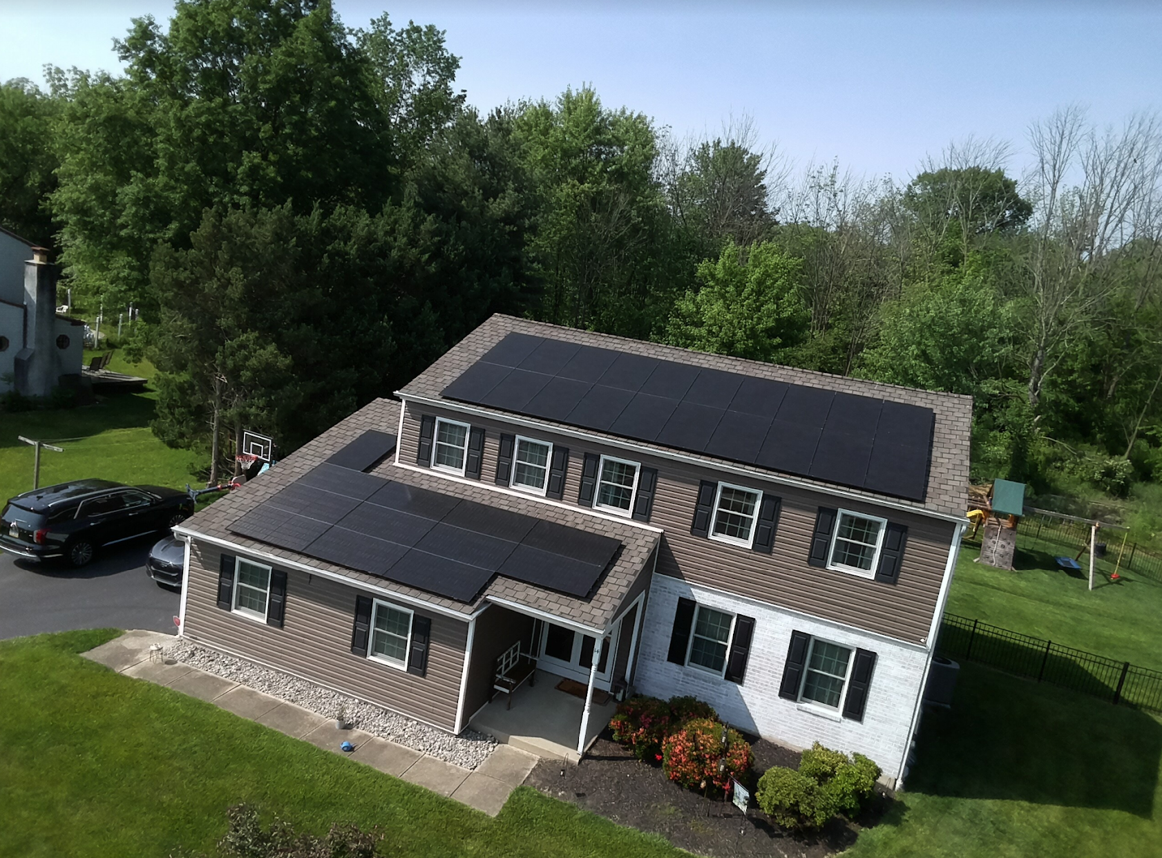 An aerial view of a house with solar panels on the roof.