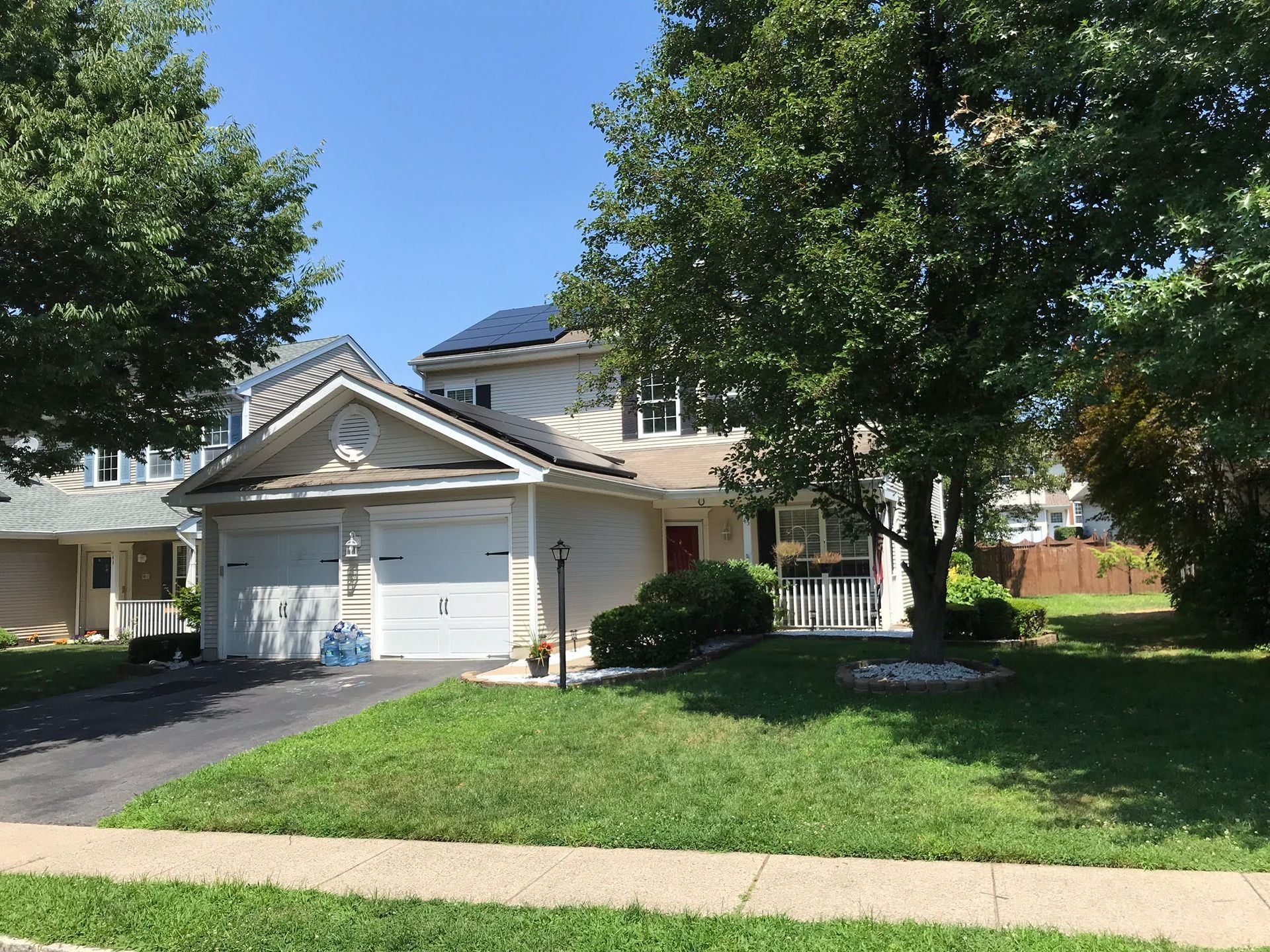 A house with a lot of grass and trees in front of it