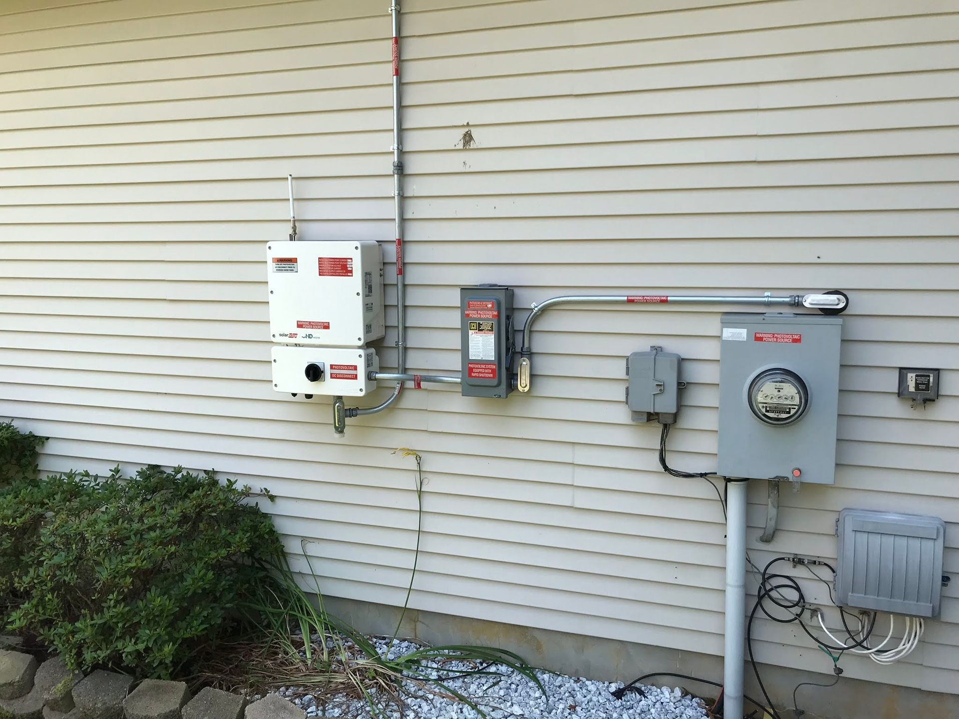 A house with a lot of electrical equipment on the side of it
