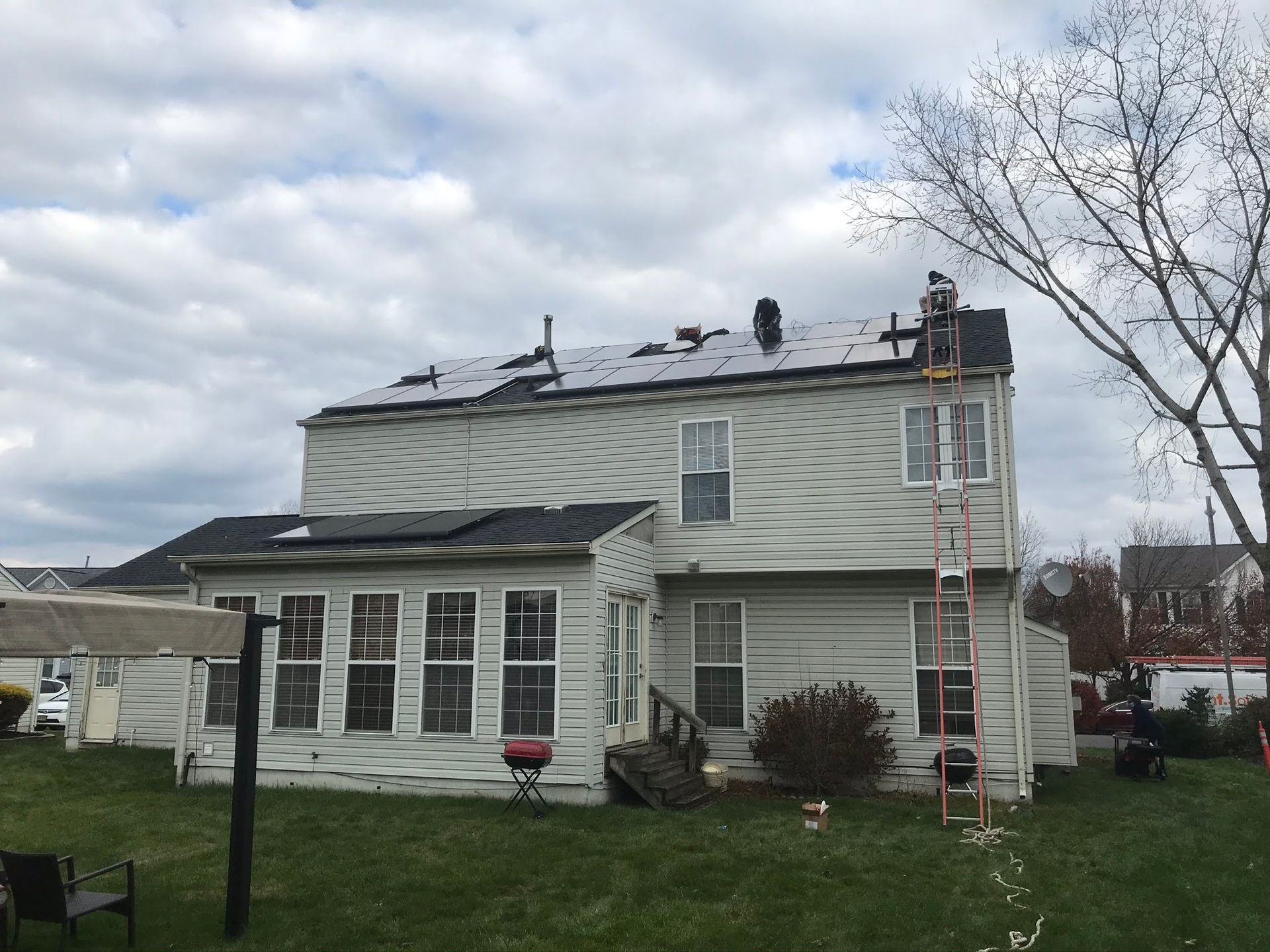 A white house with a ladder on the back of it.