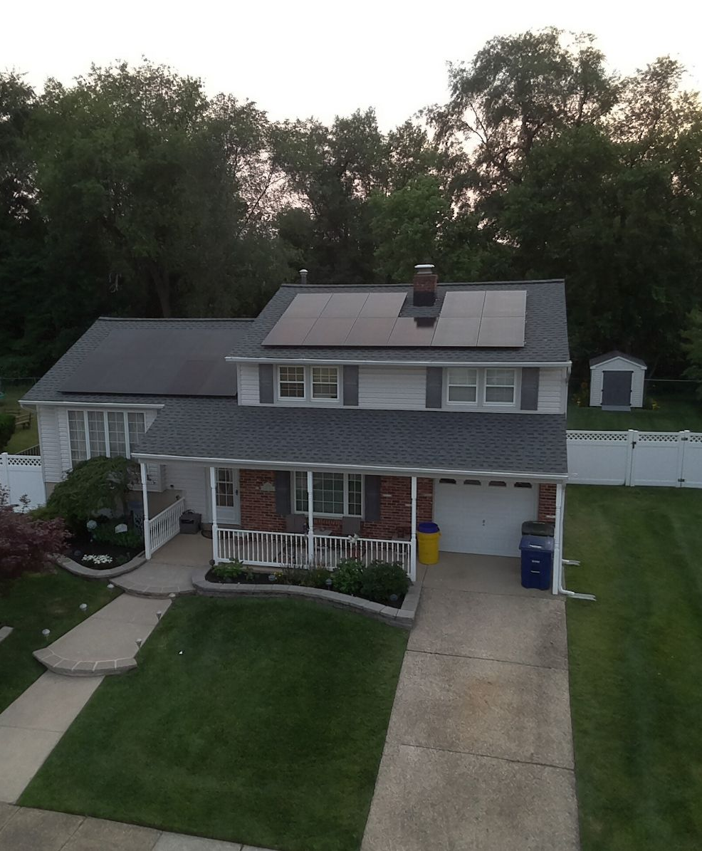 An aerial view of a house with solar panels on the roof