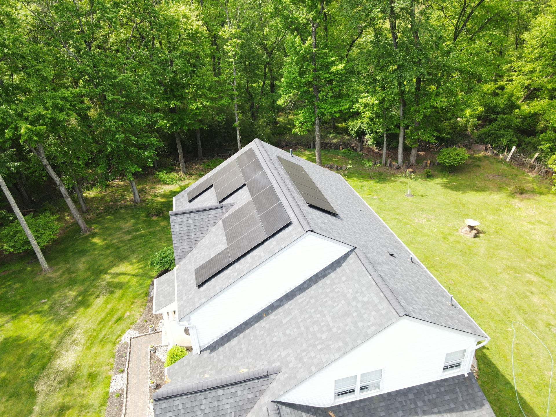 An aerial view of a house with solar panels on the roof.