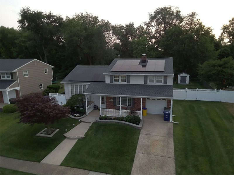 An aerial view of a house with solar panels on the roof