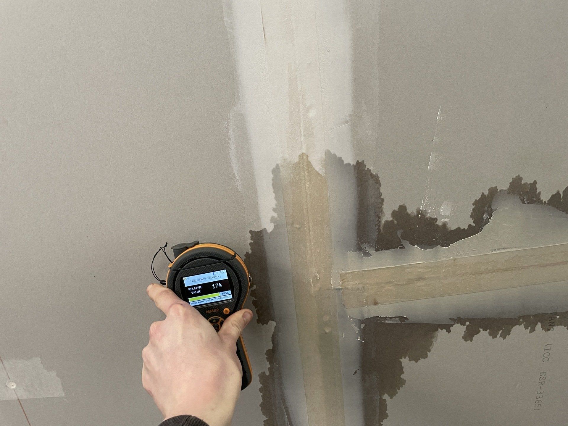 Testing a water spot on the ceiling with equipment